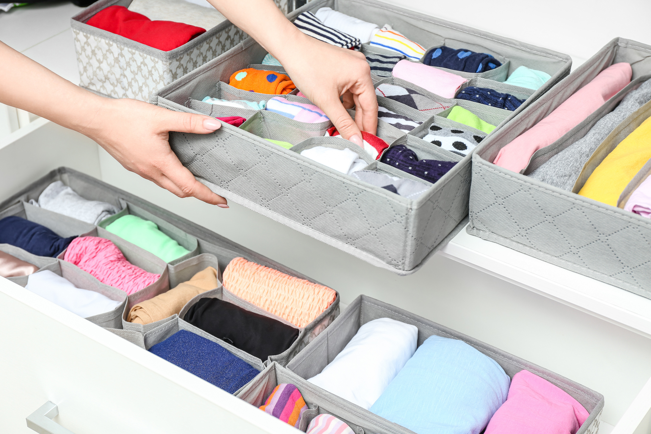 Woman with Clean Clothes in Organizer at Home