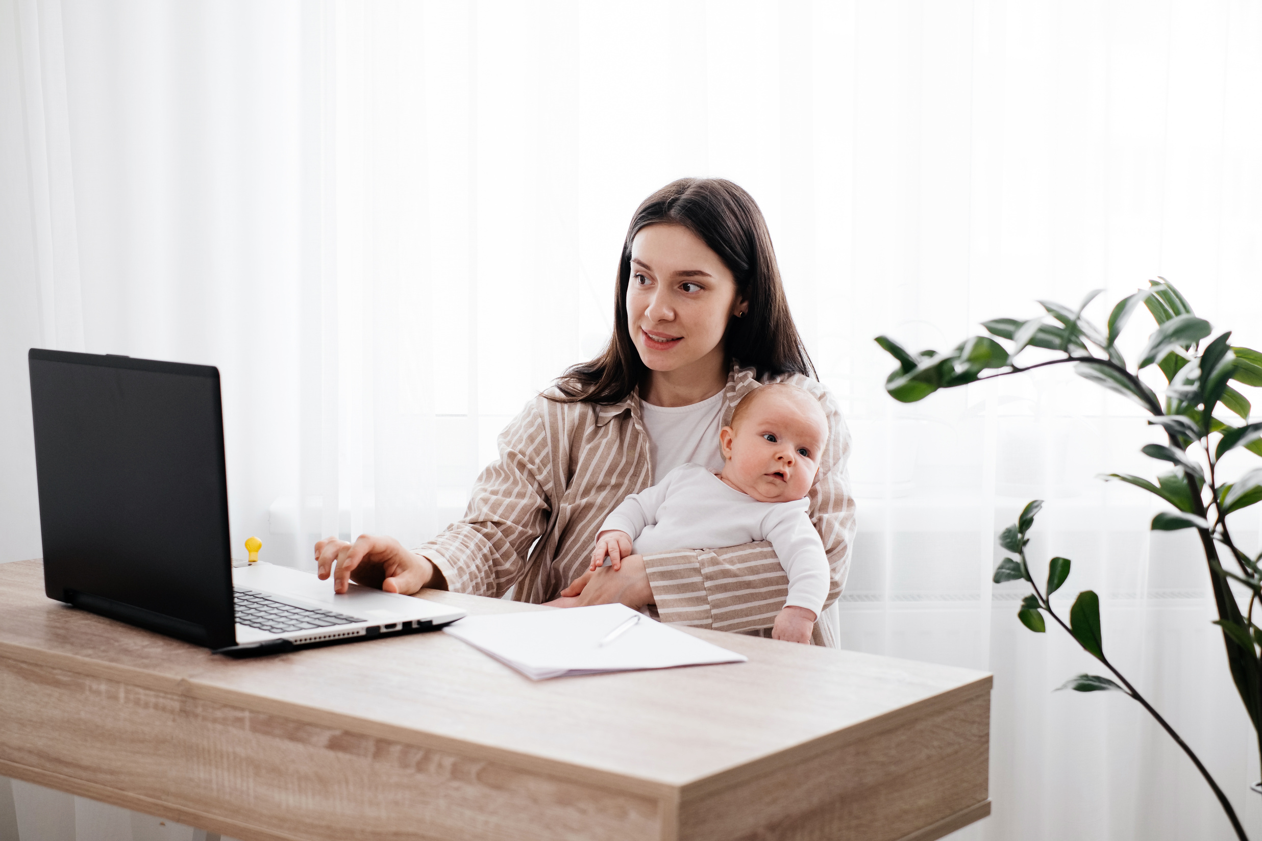 Working Mom at Home Carries Her Infant