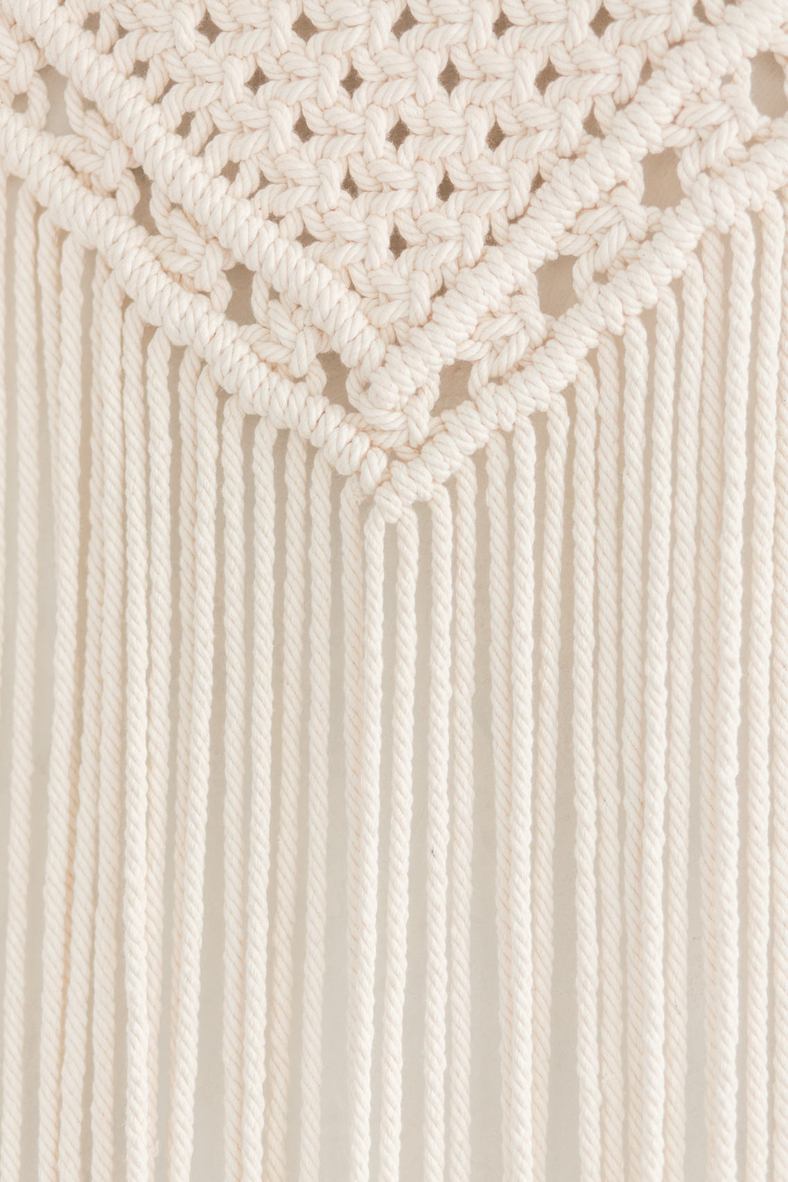 Close up of handmade cotton macrame panel. Texture. Background.